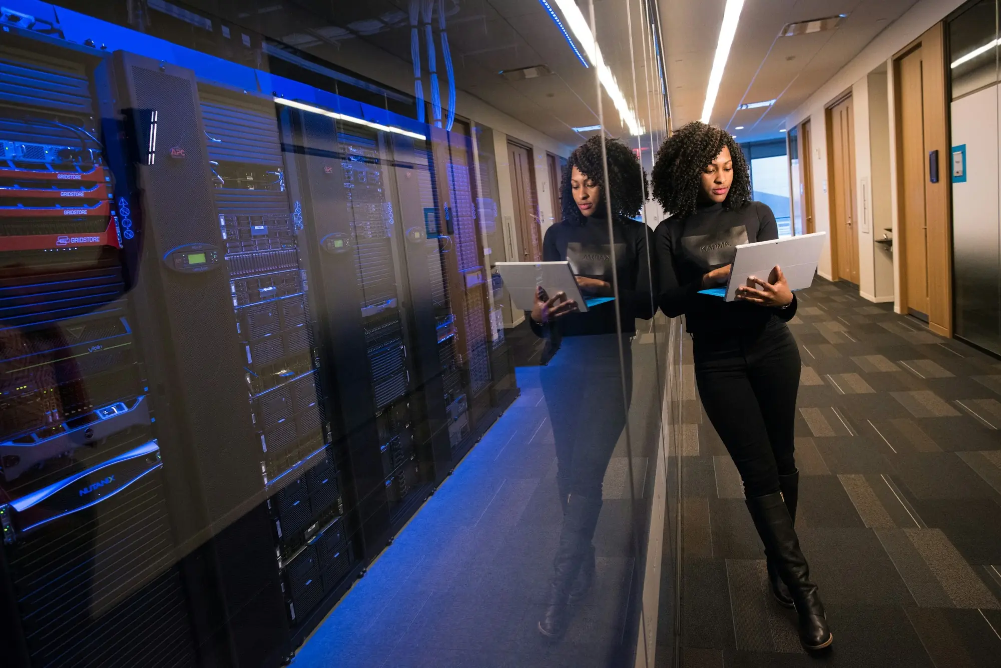 An engineer walking a datacenter aisle with a laptop