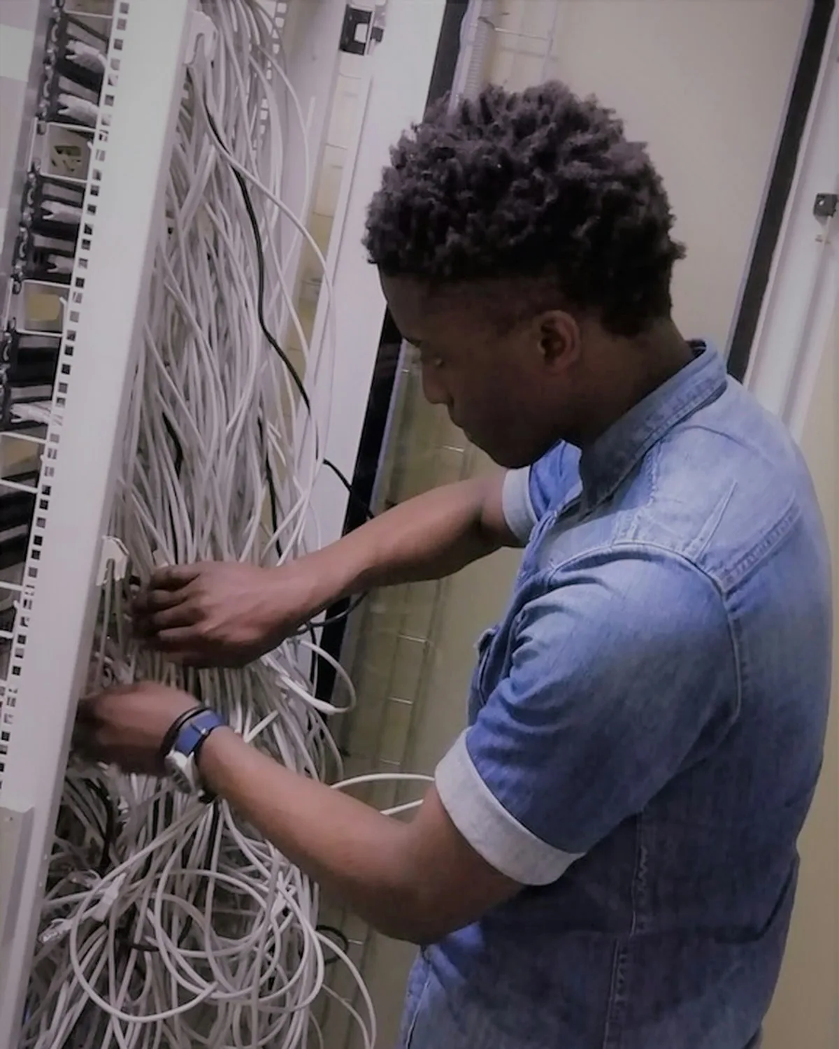 An engineer patching a rack by hand